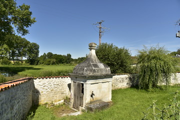 Fototapeta na wymiar Ancienne pompe à eau commune au bourg de Fontaine au Périgord Vert