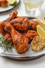 Chicken legs with sauce, rosemary and lime on a white background. Copy space.