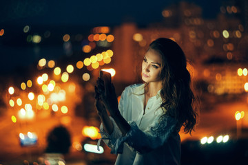 Woman over cityscape holding a smart phone texting