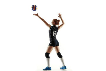 Fototapeta na wymiar Young female volleyball player isolated on white studio background. Woman in sport's equipment and shoes or sneakers training and practicing. Concept of sport, healthy lifestyle, motion and movement.