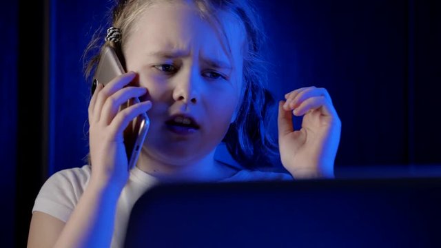 Close-up shot of a young little girl talking on her fance smartphone.