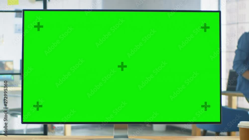 Poster Wide Green Mock-up Screen Desktop Computer Standing on the Desk in the Modern Creative Office. In the Background Bright Creative Loft for Developers and Designers where Professional Working. Zoom Out