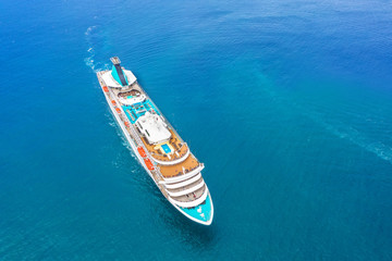 Cruise ship liner sails in the blue sea leaving a plume on the surface of the water seascape....