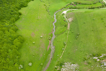 Drone view of green meadows and villages in Transylvania.