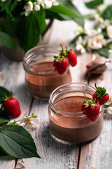 chocolate panna cotta, strawberries on rustic backdrop