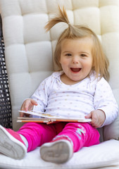 Fototapeta premium Baby. Girl. Read Book. Cute. Child. Face
