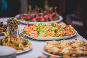 Beautifully decorated catering banquet table with different food snacks and appetizers on corporate, christmas, birthday party event or wedding celebration