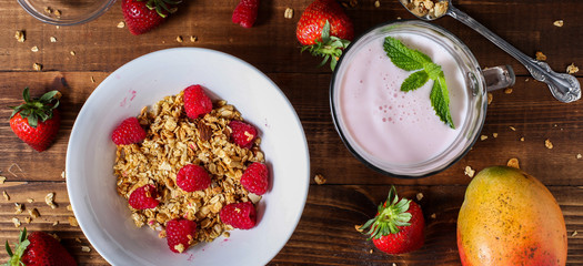 Strawberry smoothie with granola berries and mango table top view