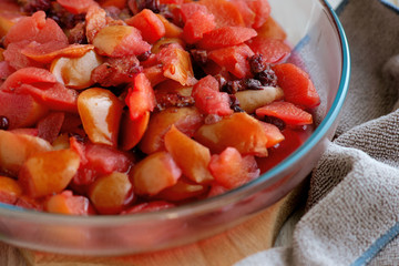 Boiled fruits and berries for fruit drinks and fruit compote. Preparation of fruit drink or fruit and berry compote. Closeup of boiled apples, grapes, pears, currants, apricots in a glass bowl. © Evgeniya369