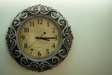 Ancient Wall Designer Wall Clock With Light Yellow Back Ground showing time 03:15 o'clock