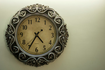 Ancient Wall Designer Wall Clock With Light Yellow Back Ground showing time 01.00 o'clock