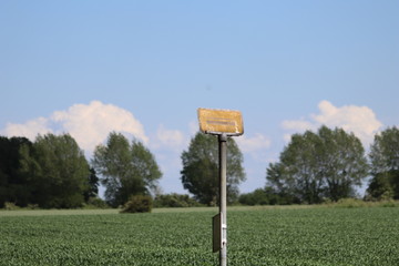 Old busstop sign on the field