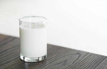 Close up glass of milk on wood table, selective focus