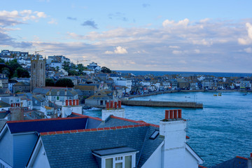 St Ives City during sunset. St Ives is a seaside town, civil parish and port in Cornwall, UK. The town lies north of Penzance and west of Camborne on the coast of the Celtic Sea