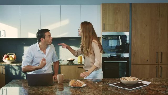 Aggressive man arguing at kitchen. Angry husband having conflict with wife.