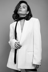 Elegant caucasian woman with dark hair in fashion white suit