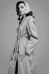 Young elegant brunette woman in coat and shawl posing in studio