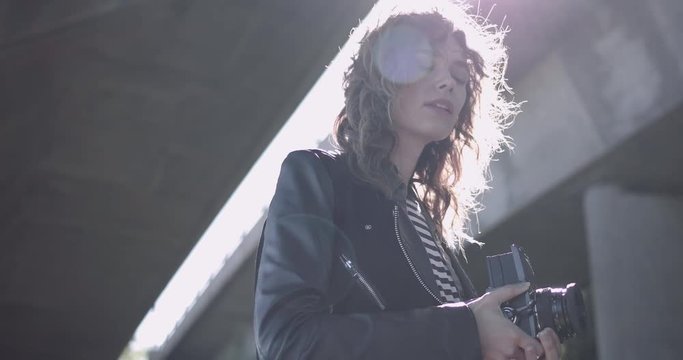 Young Adult woman photographer in urban location with retro camera