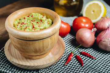 bowl with fresh guacamole on wooden table