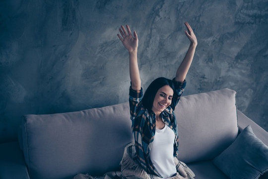 Close up photo beautiful she her lady toothy smile covered blanket just woke up eyes closed hands arms raised up overjoyed wear checkered plaid shirt lying comfy divan flat house living room indoors