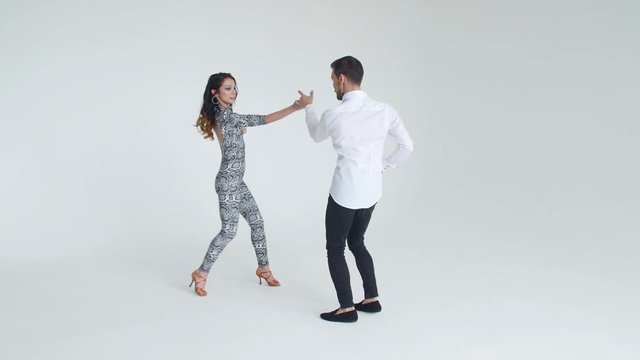Concept of love, relationships and social dancing. Young beautiful couple dancing sensual dance on a white background