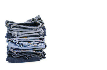 Denim blue jeans stack on white background. Clothes, fashion, charity