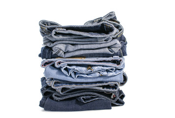 Denim blue jeans stack on white background. Clothes, fashion, charity