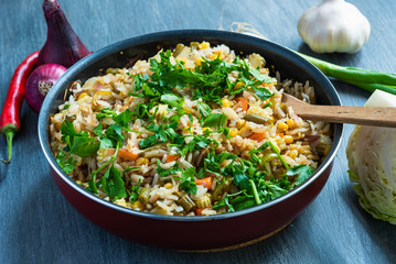 Veggie fried rice with cabbage, carrots, corn, onions, beans and peppers with chopped parsley in a pan - a popular dish of Indian and Asian cuisine