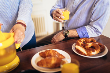 Senior couple having fun preparing healthy food on breakfast in the kitchen, close up.