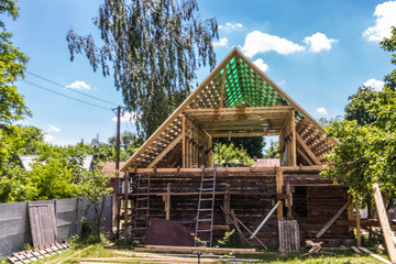 Fototapeta na wymiar Installation of a new wooden roof on a dwelling house by a team of joiners and roofers
