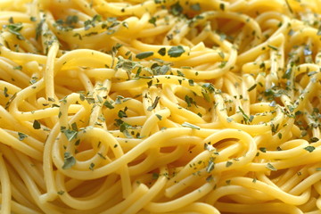 Spaghetti prepared with basil herbs and olive oil, closeup