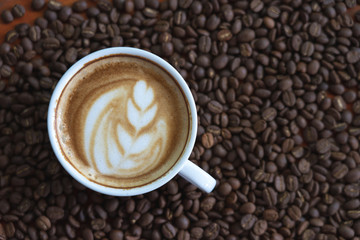 white coffee mug.  Coffee is a latte. table on the wooden table in vintage style, taken from the top view, see the froth of milk foam.
