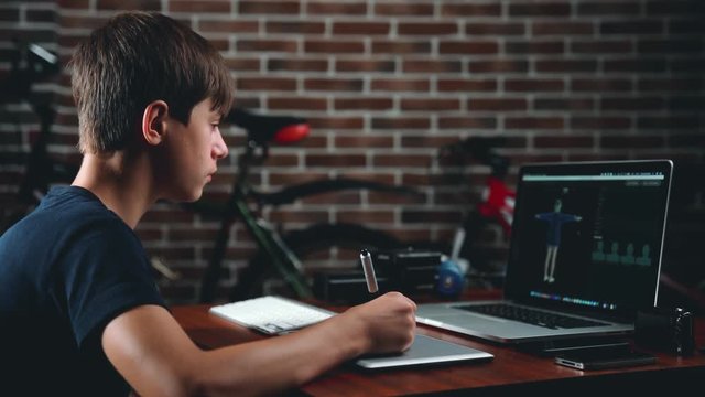 Freelance teen 3d illustrator, content maker, working 3d modelling program and creates a character for further animation on the laptop in house office.