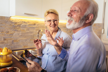 Modern senior couple shopping online with tablet and credit card