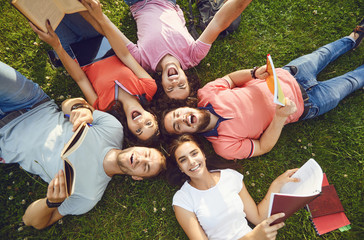 Young people are laughing while lying on the grass
