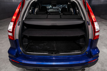 Close up Rear view of a SUV  blue car with open trunk in garage. Empty car trunk