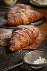 fresh croissants on a dark board, top view