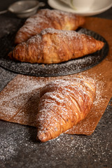 fresh croissants on a dark board, top view