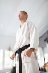 Serious aikido master wearing kimono with black belt