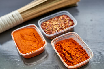 Spices in plastic containers with bamboo brush