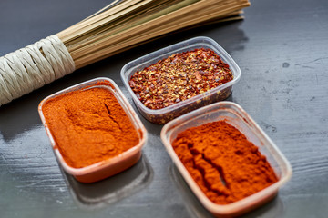 Spices in plastic containers with bamboo brush