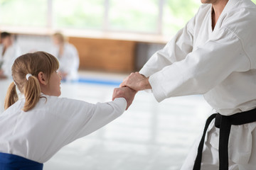 Cute girl preparing for sport competition practicing aikido