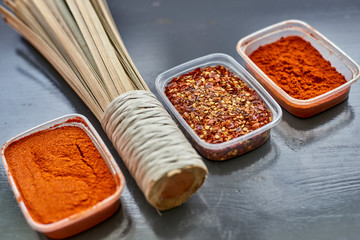 Spices in plastic containers with bamboo brush