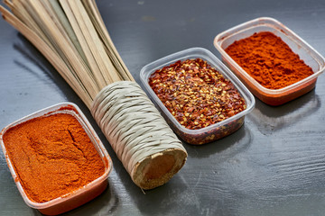 Spices in plastic containers with bamboo brush