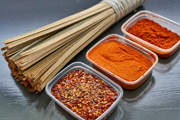 Spices in plastic containers with bamboo brush