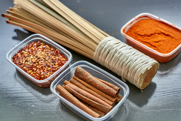 Spices in plastic containers with bamboo brush