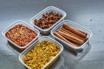 Spices in plastic containers with bamboo brush