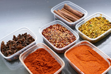 Spices in plastic containers with bamboo brush