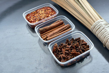 Spices in plastic containers with bamboo brush