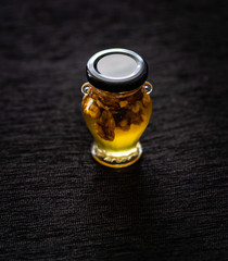 honey with walnuts in a jar from Greece on a black background